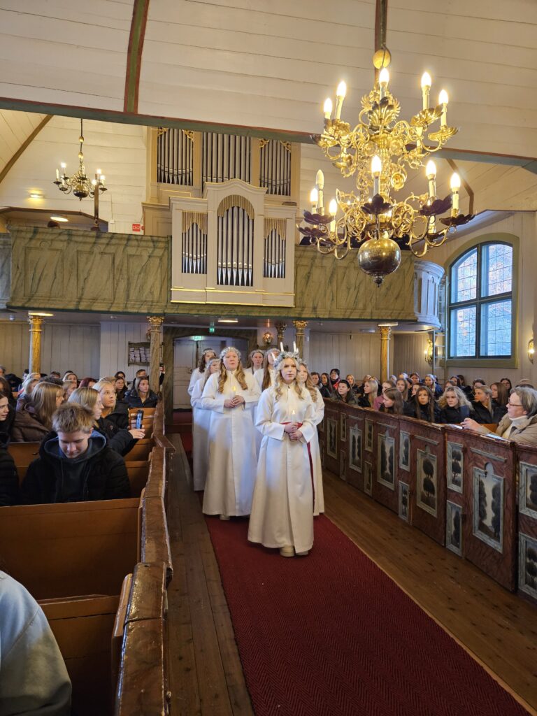 Lucia-neito Ellen Kuusiniemi johtaa kulkueen kirkkoon.